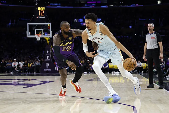 Spurs center Victor Wembanyama, right, drives to the basket against Lakers forward LeBron James